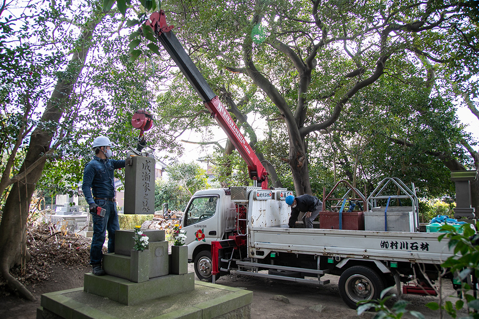 クレーンを使って墓石を撤去